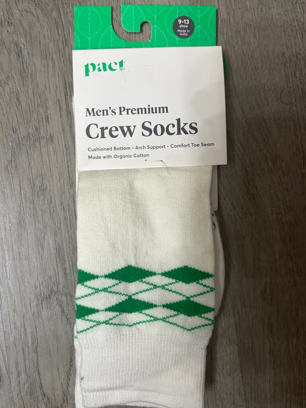 Pact white socks with green packaging